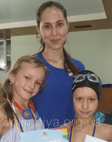 На фото методист курсу з плавання для дітей у школі Олімпія Юлія Багмут і її учні